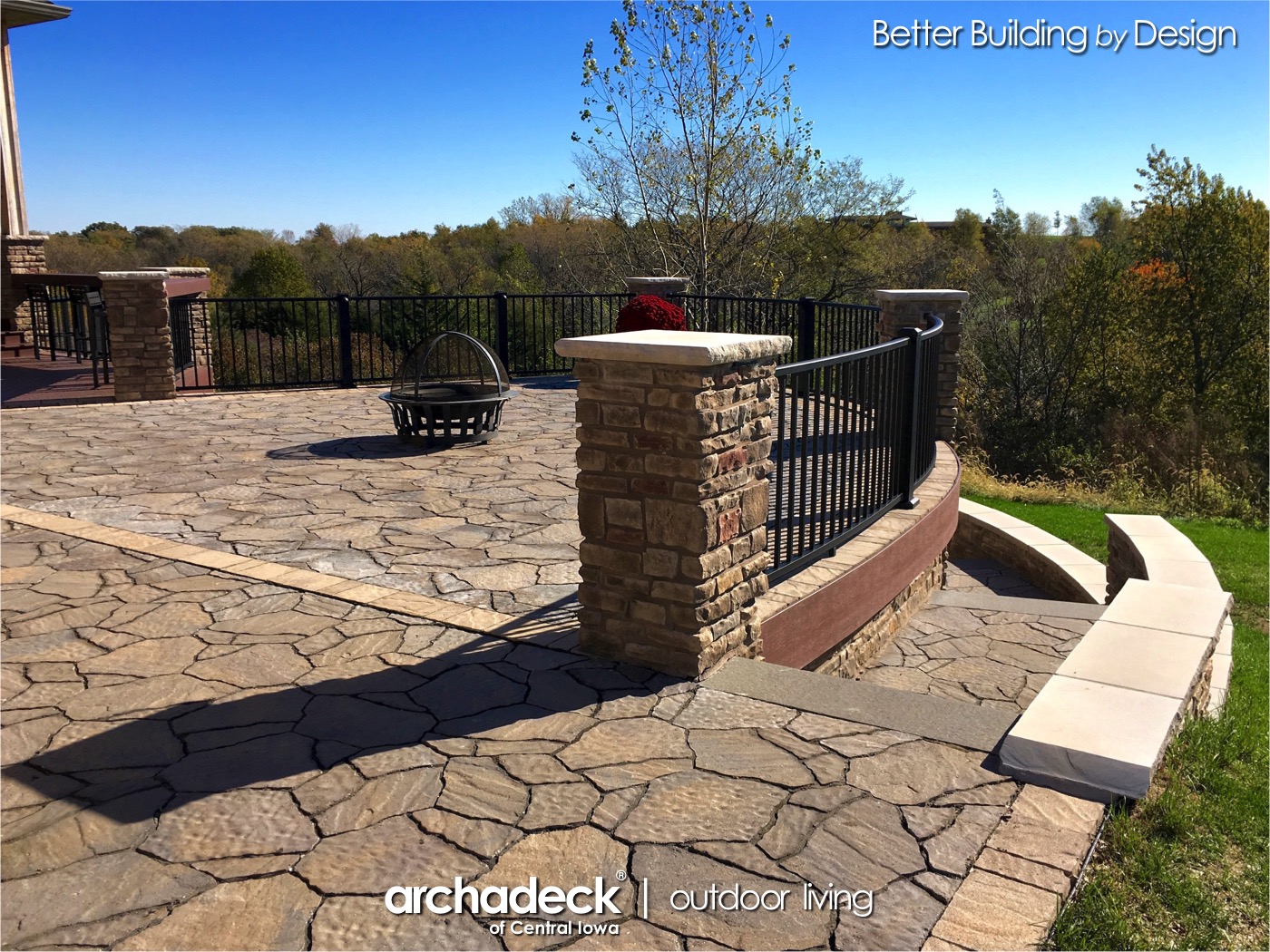 A stone patio with a black fence